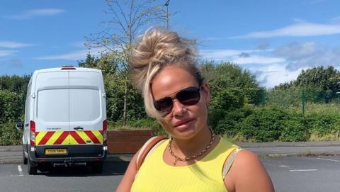 Woman in a yellow vest top with sunglassses on speaks to 鶹ҳ News NI about parking charges