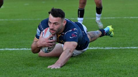 Jake Connor prepares to touch down for his first try as he slides over the line with ball tucked under his arm