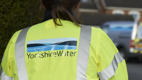 Woman wearing Yorkshire Water hi-vis vest facing away from camera