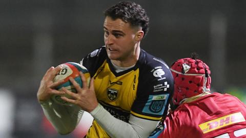 Harry Wilson of Dragons is challenged by John Hodnett of Munster 