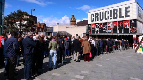 Spectators queue outside the Crucible Theatre in Sheffield