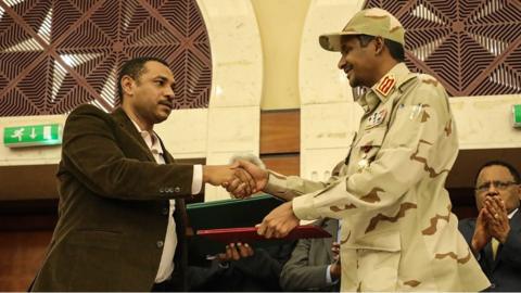 Ahmad al-Rabiah and Mohamed Hamdan Dagalo shake hands