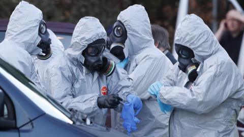 Police seen putting on protective suits and gas masks in preparation to carry out further investigation work in Salisbury