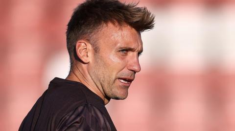 Chris Hogg wearing a black top with his mouth slightly open