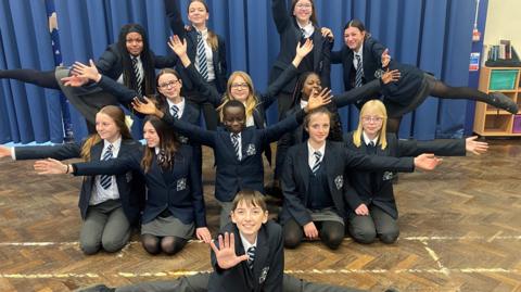 Pupils from the dance troop wearing their  school uniform and in dance poses