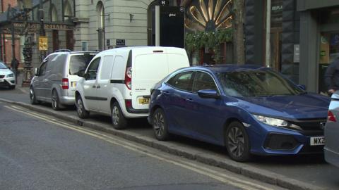 Vehicles parked on the pavement on Bedford Street in Belfast city centre