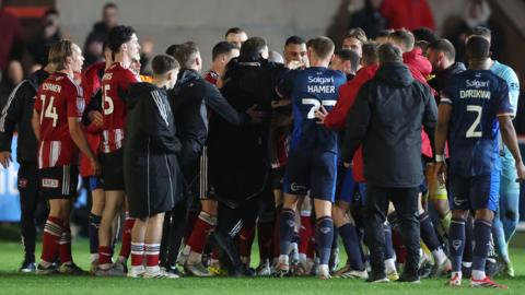 Exeter and Lincoln players clash after the full-time whistle