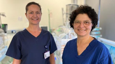 Beth Hawken and Eleonora Forbes in navy scrubs, smiling