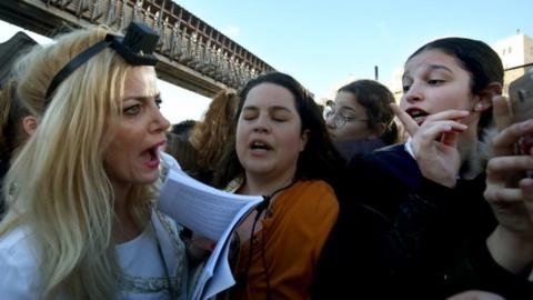 A member of the liberal Jewish religious movement "Women of the Wall" argues with Ultra Orthodox Jewish girls interrupting her prayers during an event marking the organisation's 30th anniversary at Judaism's holiest prayer site of the Western Wall in the Old City of Jerusalem on 8 March 2019