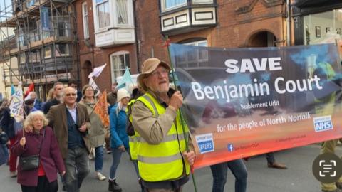 People marching in Cromer holding a banner