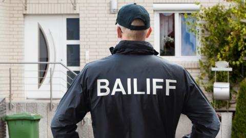 bailiff outside a house