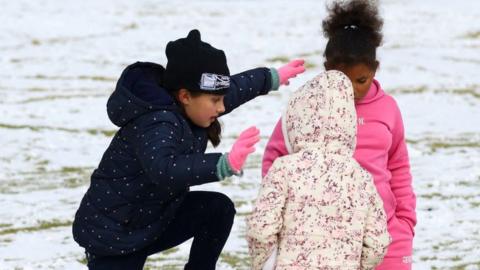 Girls play with a large snow ball at a school in Brackenhurst, south of Johannesburg, on 10 July.