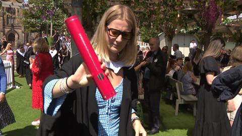 Graduate holds an empty degree scroll