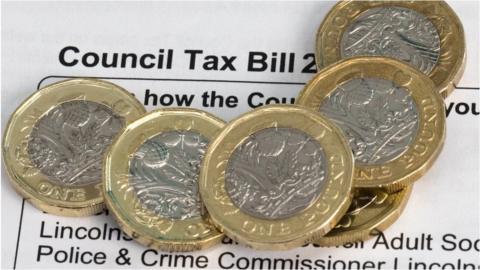 Council tax bill with pound coins on it