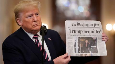 Trump holds newspaper reading, 'acquitted'