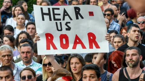 A participant holds a sign during a rally in front of the Parliament building in Tbilisi on June 21, 2019