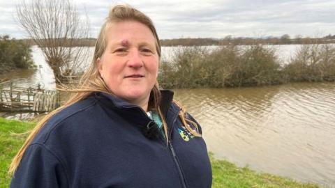 Debbie Wilkins standing in front of a flooded field