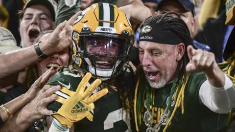 Aaron Jones celebrates a touchdown with a Green Bay Packers fan