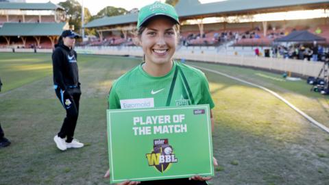 Melbourne Stars all-rounder Tess Flintoff smiles as she holds up the player of the match placard