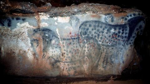 Wild horses, hand stencils and other marks on a rock surface in Pech-Merle Cave, France around 30,000 years ago