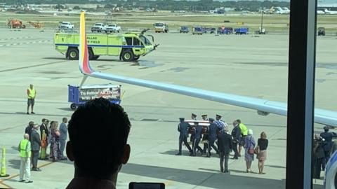 Col Knight is carried off the plane in Dallas