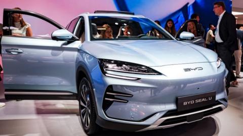 People looking at a BYD Seal U electric car at the IAA Mobility 2023 international motor show in Munich, Germany.