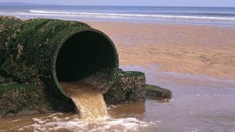 An outlet pipe discharging sewage on to a North sea beach in Hartlepool