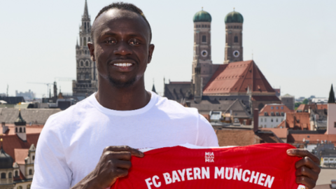 Sadio Mane holding a Bayern Munich shirt after joining the German club from Liverpool