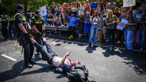 Police officers remove an activist from the Extinction Rebellion protest group on the A12, during the 'XR opposes fossil subsidies' demonstration in The Hague, The Netherlands, 27 May 2023.