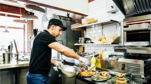 Chef Preparing Food For Customers - stock photo