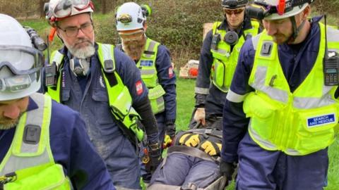 A group of four trainee search and rescuers carrying a person on stretcher