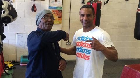 Stanford Robinson left points at at his so Steve. The pair are photographed in a boxing gym.