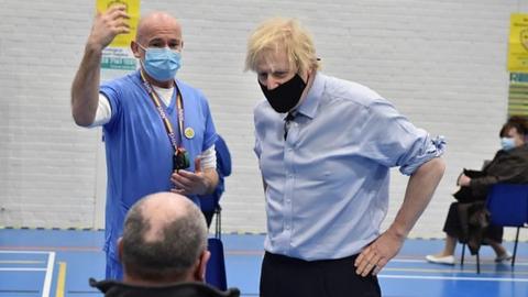 Boris Johnson speaks to a man waiting for a Covid-19 vaccine at a centre in Fermanagh