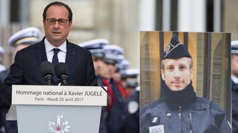 French President Francois Hollande pays tribute to slain police officer Xavier Jugele at the Paris police headquarters in Paris