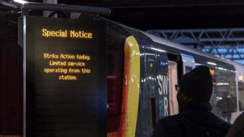 A train passenger looks at a notice advertising strike action