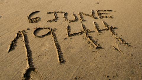 Date of D-Day landings written in sand on beach in Normandy, France