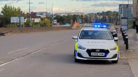 A police car and cordoned-off area