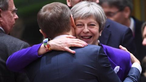 Theresa May greets European Council president Donald Tusk at the EU summit in Brussels