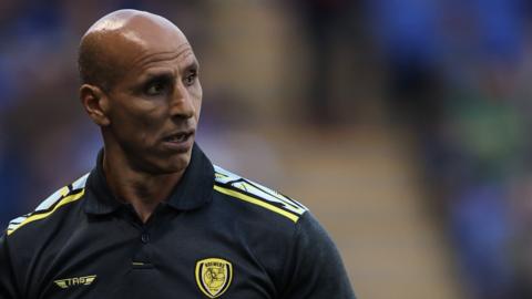 Burton boss Dino Maamria looks back across the pitch