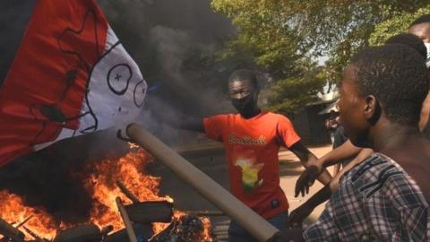 People burn France's flag during a protest, calling for Burkina Faso's President Roch Kabore to resign and for departure of French forces that patrol the country, in Ouagadougou, Burkina Faso November 27, 2021.