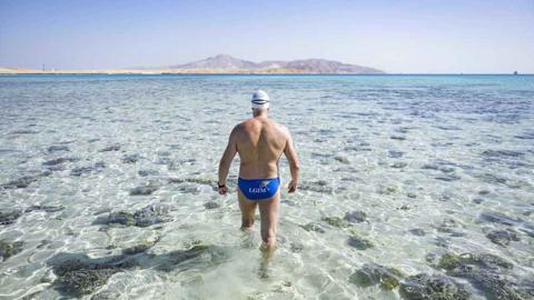 Swimmer Lewis Pugh walking into the sea