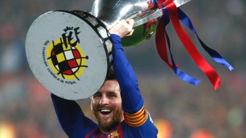 Messi holding the La Liga trophy