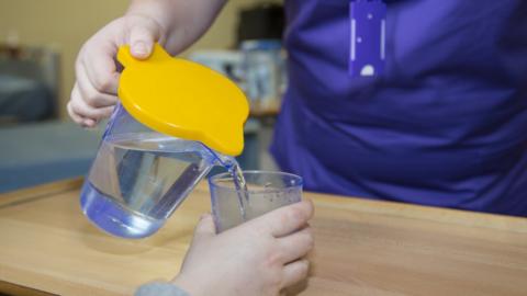 A picture of a water jug with a yellow lid