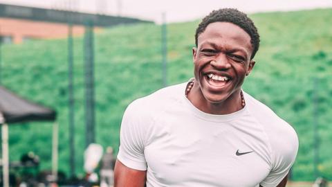 Emmanuel Okoye laughs during a training session