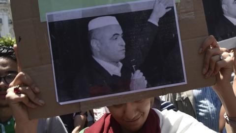 Algerian students hold a sign following the reported death of political activist Kamel Eddine Fekhar, on May 28, 2019