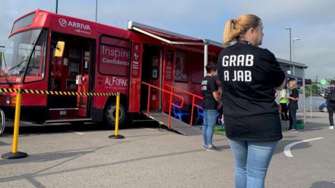 Health worker in a 'Grab a Jab' T-shirt by Boro vaccination bus