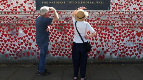 A couple look at the National Covid Memorial Wall in London