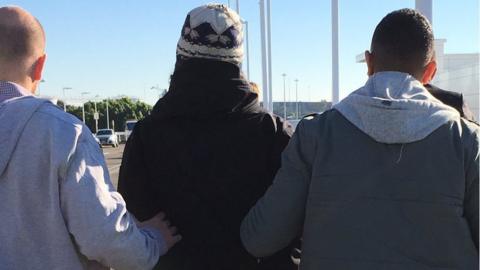 A photo posted on Twitter shows two plainclothes officers outside the terminal leading the man in handcuffs.