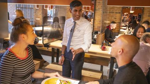 Chancellor Rishi Sunak speaks to diners at a Wagamamas restaurant