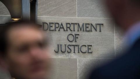 A "Department of Justice" sign is seen on the wall of the US Department of Justice building in Washington, DC on April 18, 2019